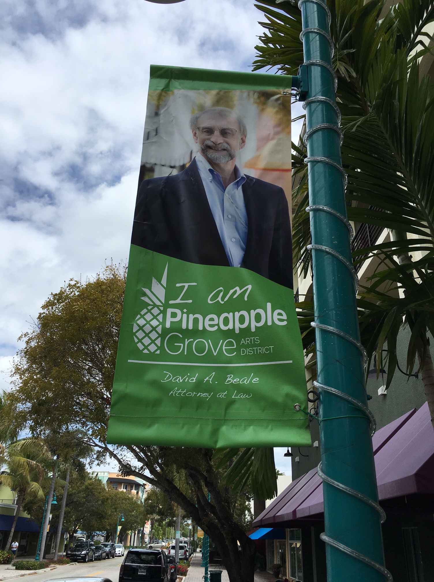 Pineapple Grove banner on a light pole with a photo of David A. Beale, lawyer.